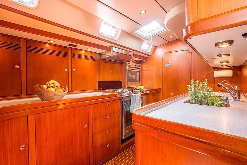 a kitchen with wooden cabinets aboard PAN Yacht for Sale