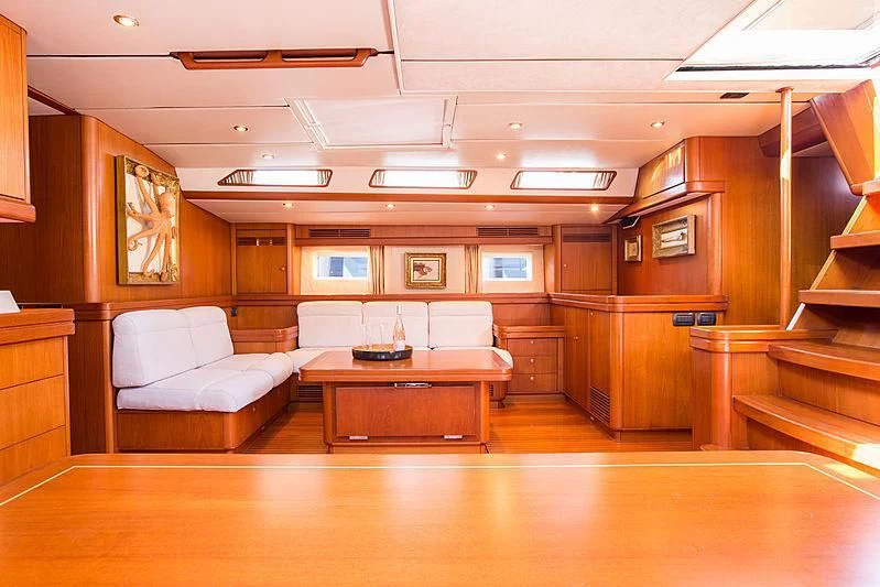 a room with a table and couch aboard PAN Yacht for Sale