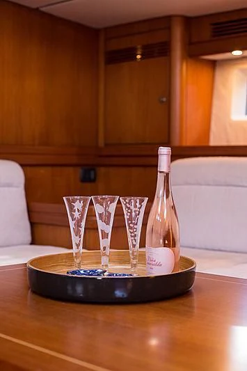 a bottle of wine and glasses on a table aboard PAN Yacht for Sale