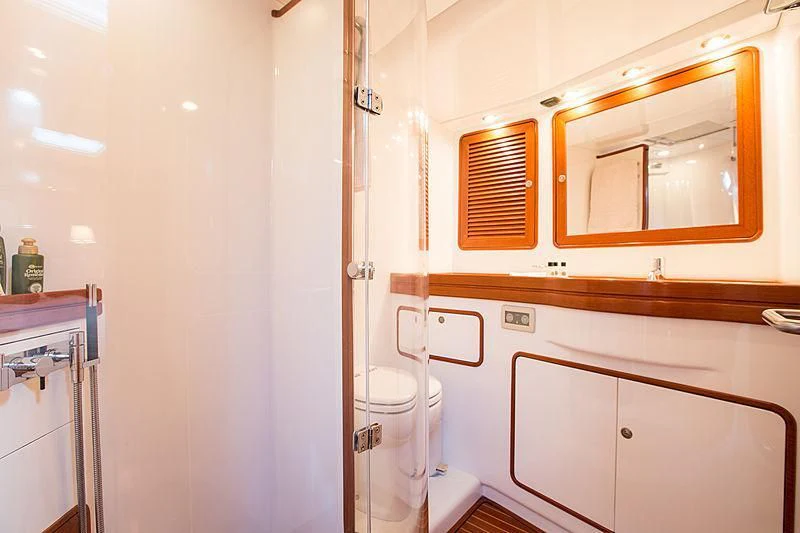 a bathroom with a toilet and a mirror aboard PAN Yacht for Sale