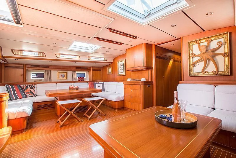 a living room with a table and couches aboard PAN Yacht for Sale