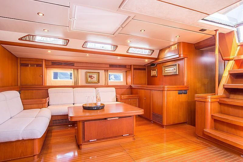 a room with a table and couch aboard PAN Yacht for Sale