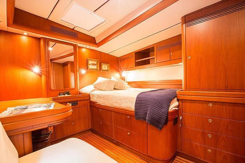 a bedroom with a bed and a desk aboard PAN Yacht for Sale