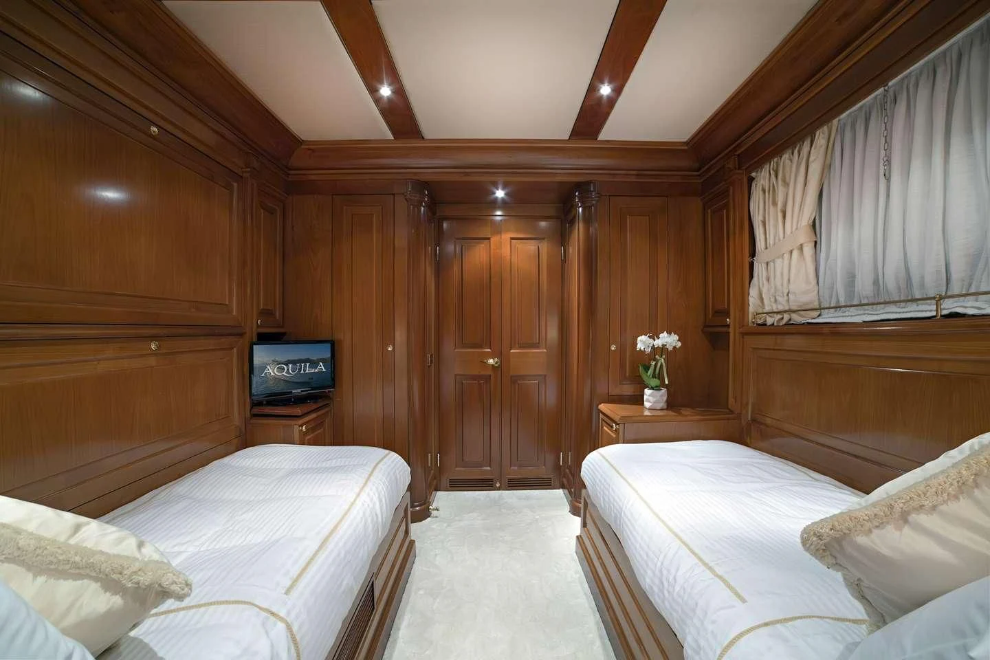a room with a bed and a television aboard AQUILA Yacht for Sale