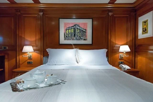 a bed with a tray of food aboard AQUILA Yacht for Sale