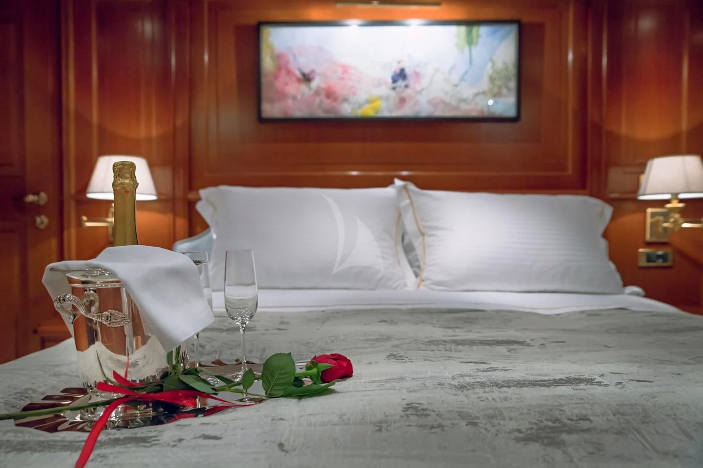 a bed with a white pillow and a red wall aboard AQUILA Yacht for Sale