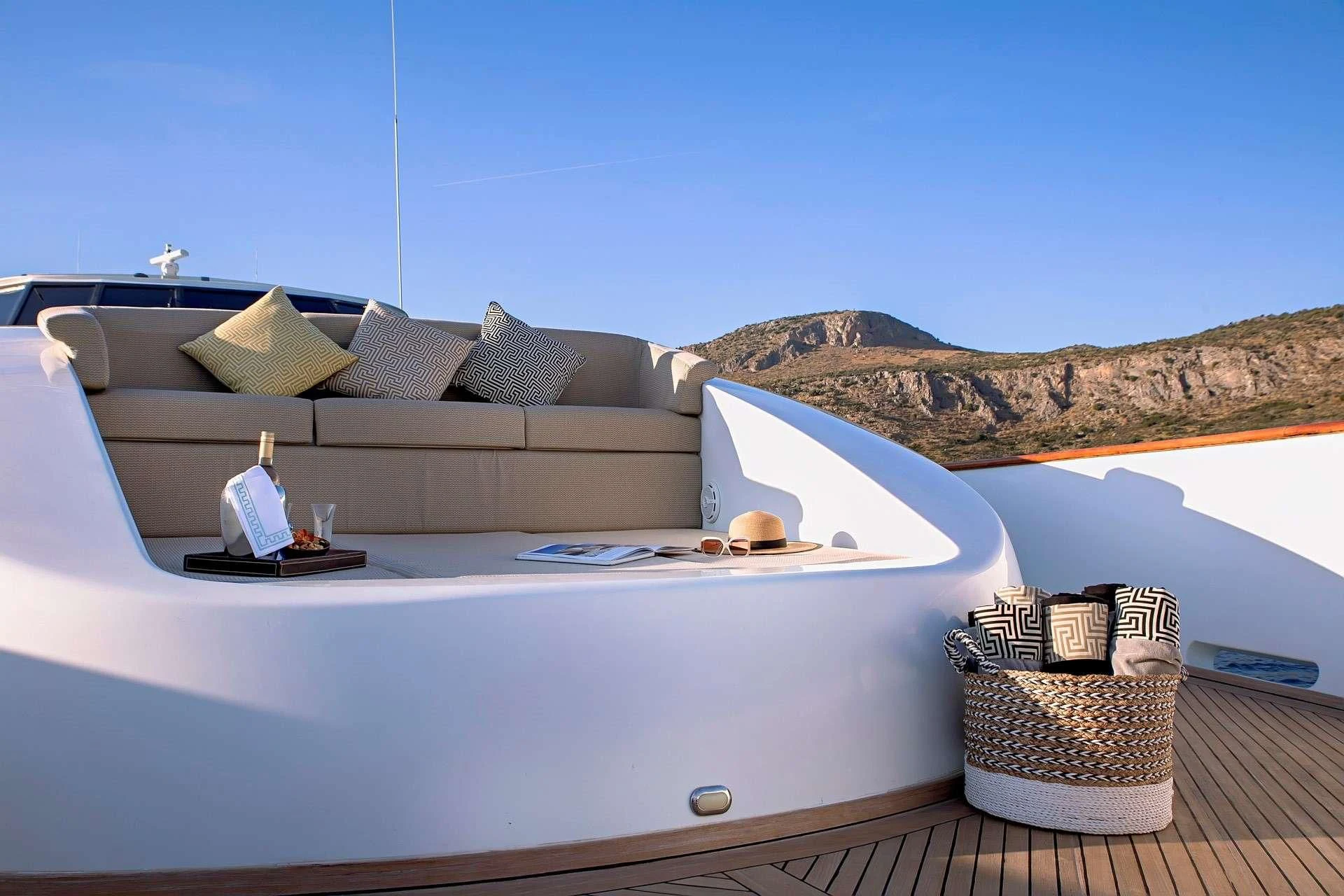a white couch with a white table and a white table with a white tablecloth and a white aboard AQUILA Yacht for Sale