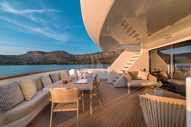 a large open area with a table and chairs and a view of the ocean aboard AQUILA Yacht for Sale