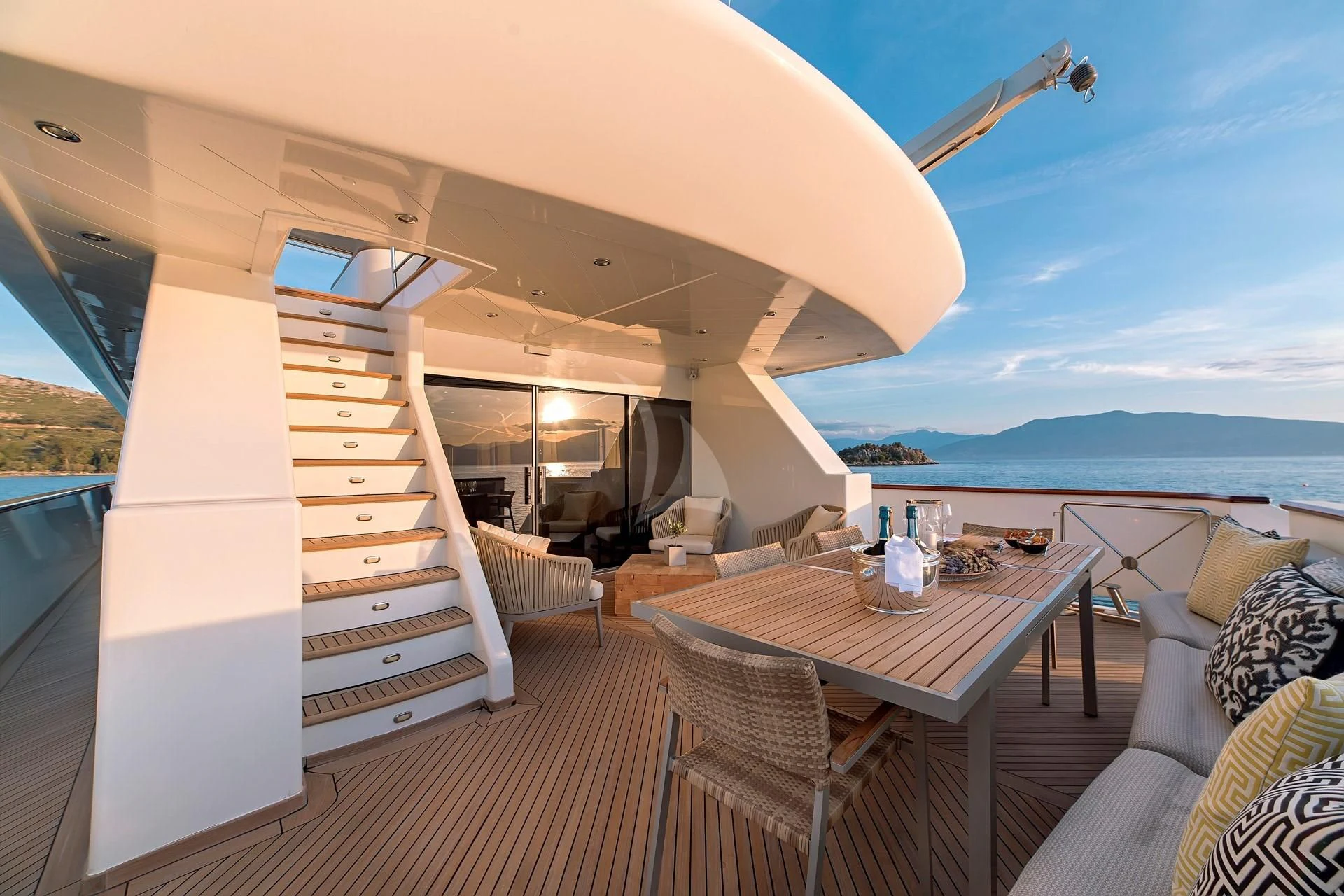 a deck with a table and chairs on it aboard AQUILA Yacht for Sale