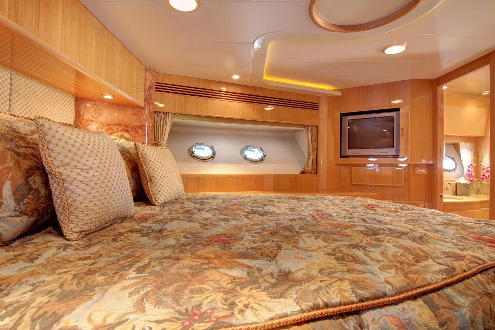 a bed with a television on the wall aboard UNSINKABLE II Yacht for Sale