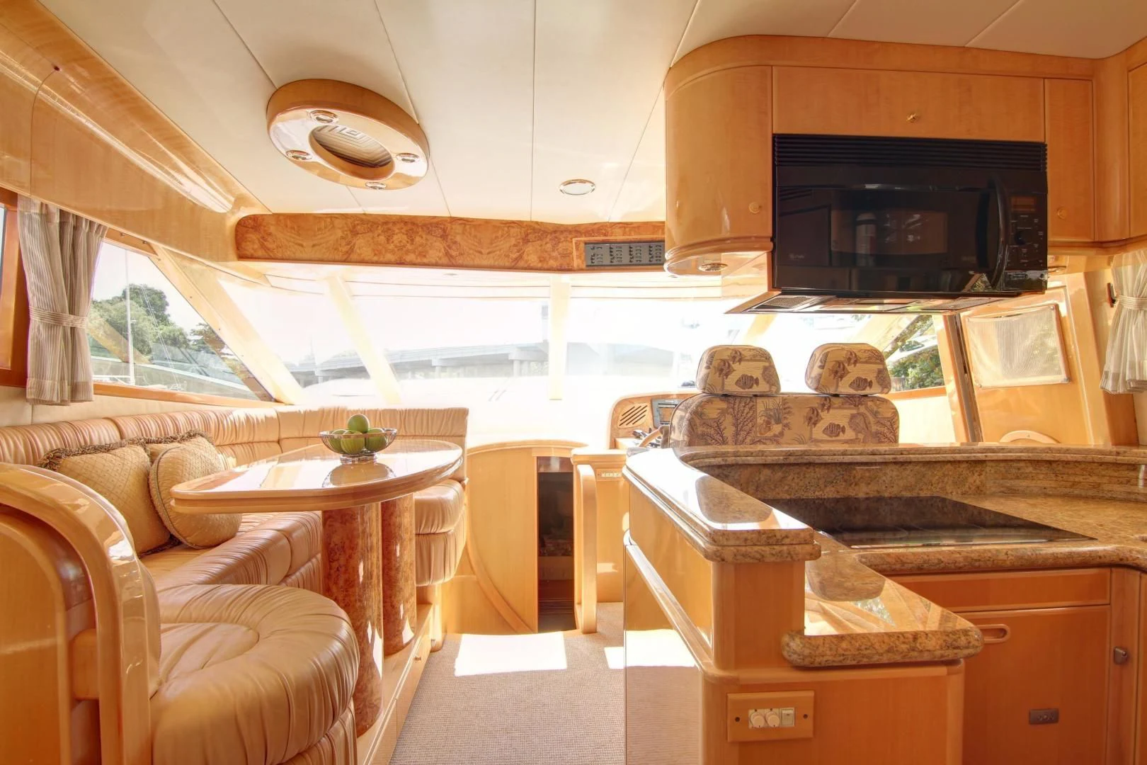 a living room with a large wood table and a large fireplace aboard UNSINKABLE II Yacht for Sale