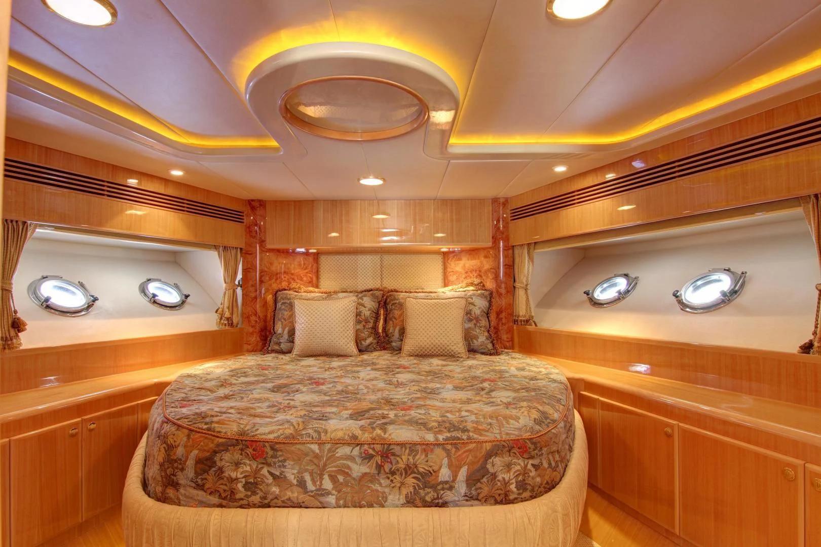 a room with a bed and a chandelier aboard UNSINKABLE II Yacht for Sale
