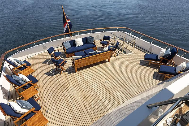 a deck with chairs and a table on it aboard GLACIAL BEAR Yacht for Sale