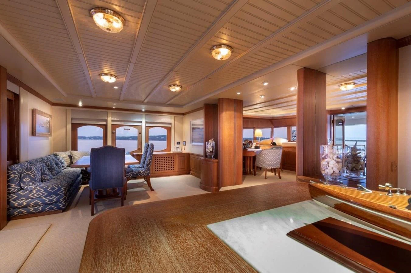 a large living room with a large wood table and chairs aboard GLACIAL BEAR Yacht for Sale