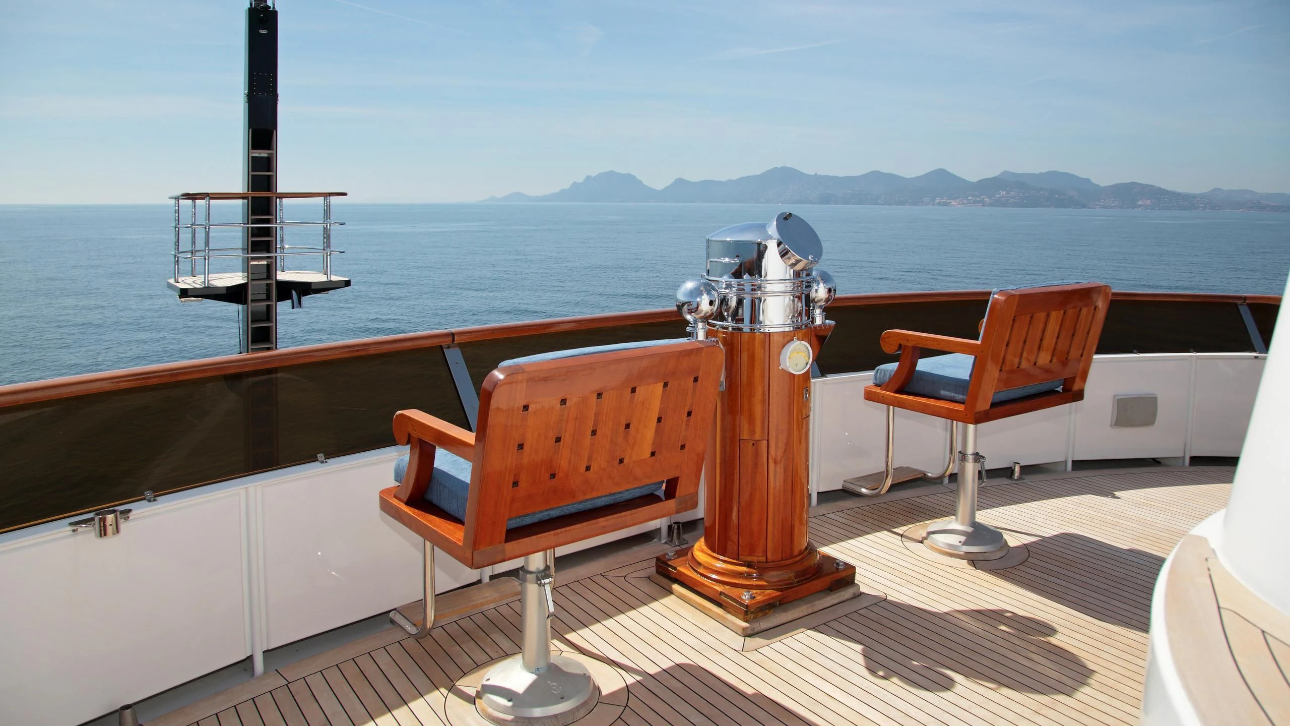 a table and chairs on a deck overlooking a body of water aboard GLACIAL BEAR Yacht for Sale