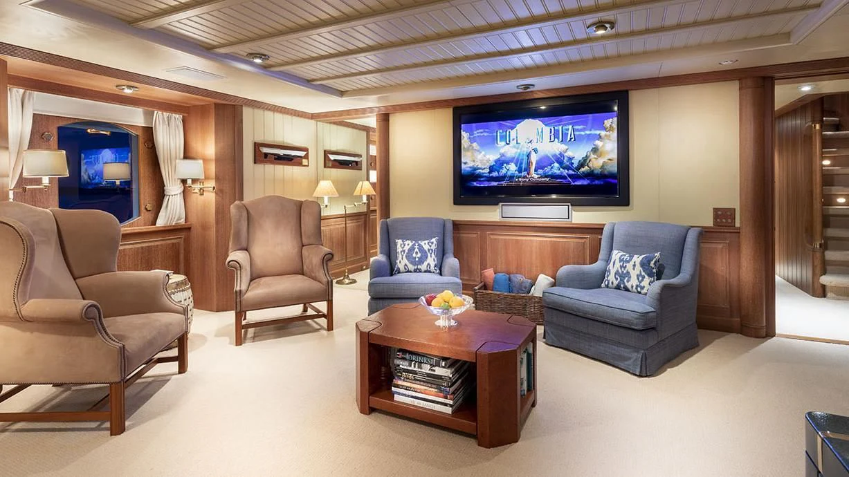 a living room with a tv and a table aboard GLACIAL BEAR Yacht for Sale