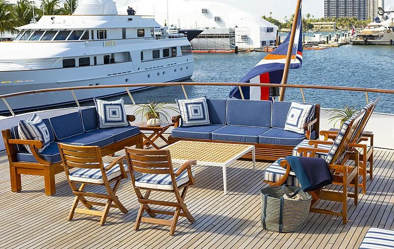 a deck with chairs and a boat in the background aboard GLACIAL BEAR Yacht for Sale