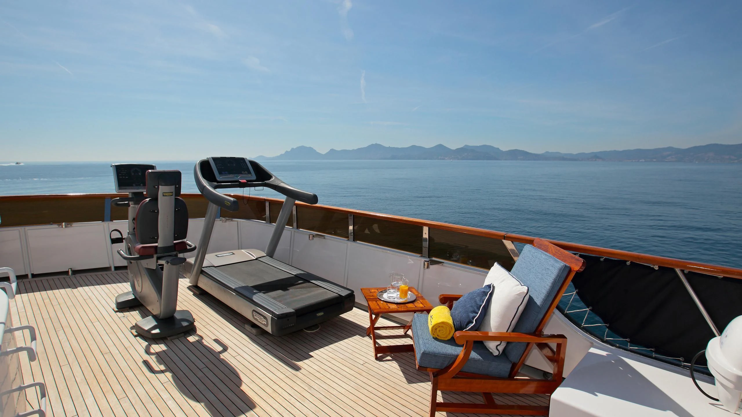 a deck with a view of the ocean and mountains aboard GLACIAL BEAR Yacht for Sale