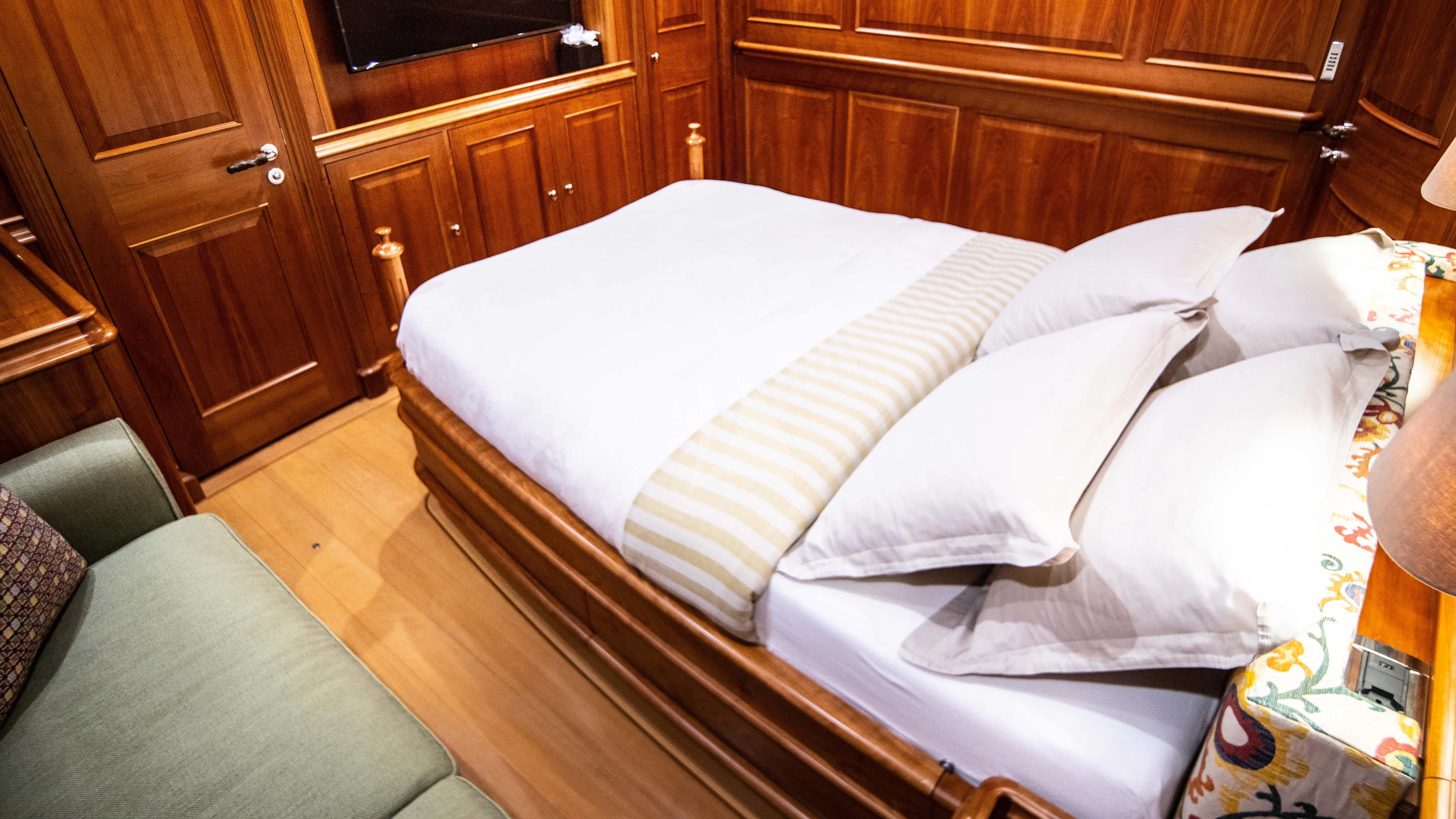 a bed with white sheets aboard ATHOS Yacht for Sale