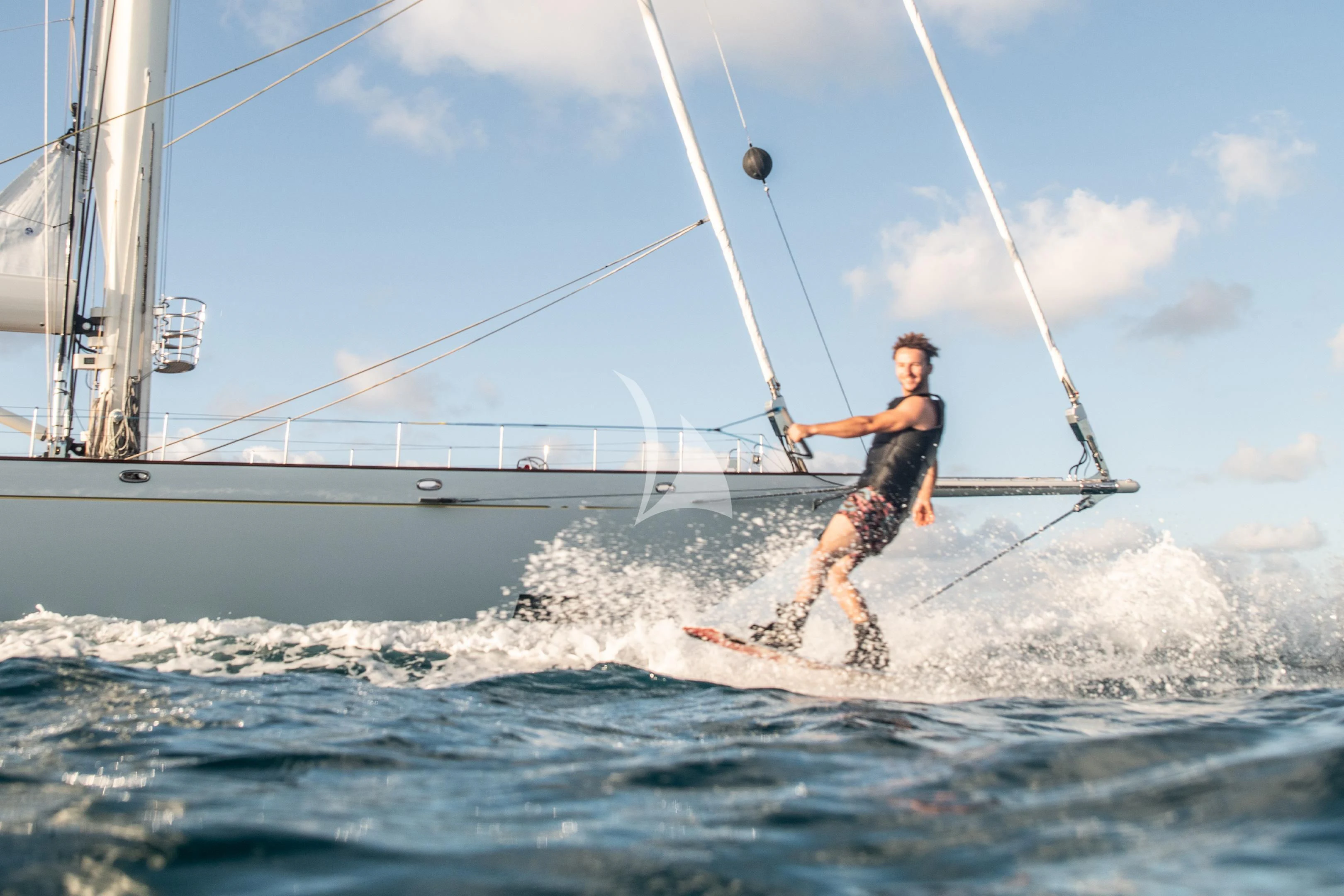 a man surfing on the waves aboard ATHOS Yacht for Sale