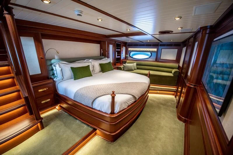 a bedroom with a bed and a wood door aboard ATHOS Yacht for Sale