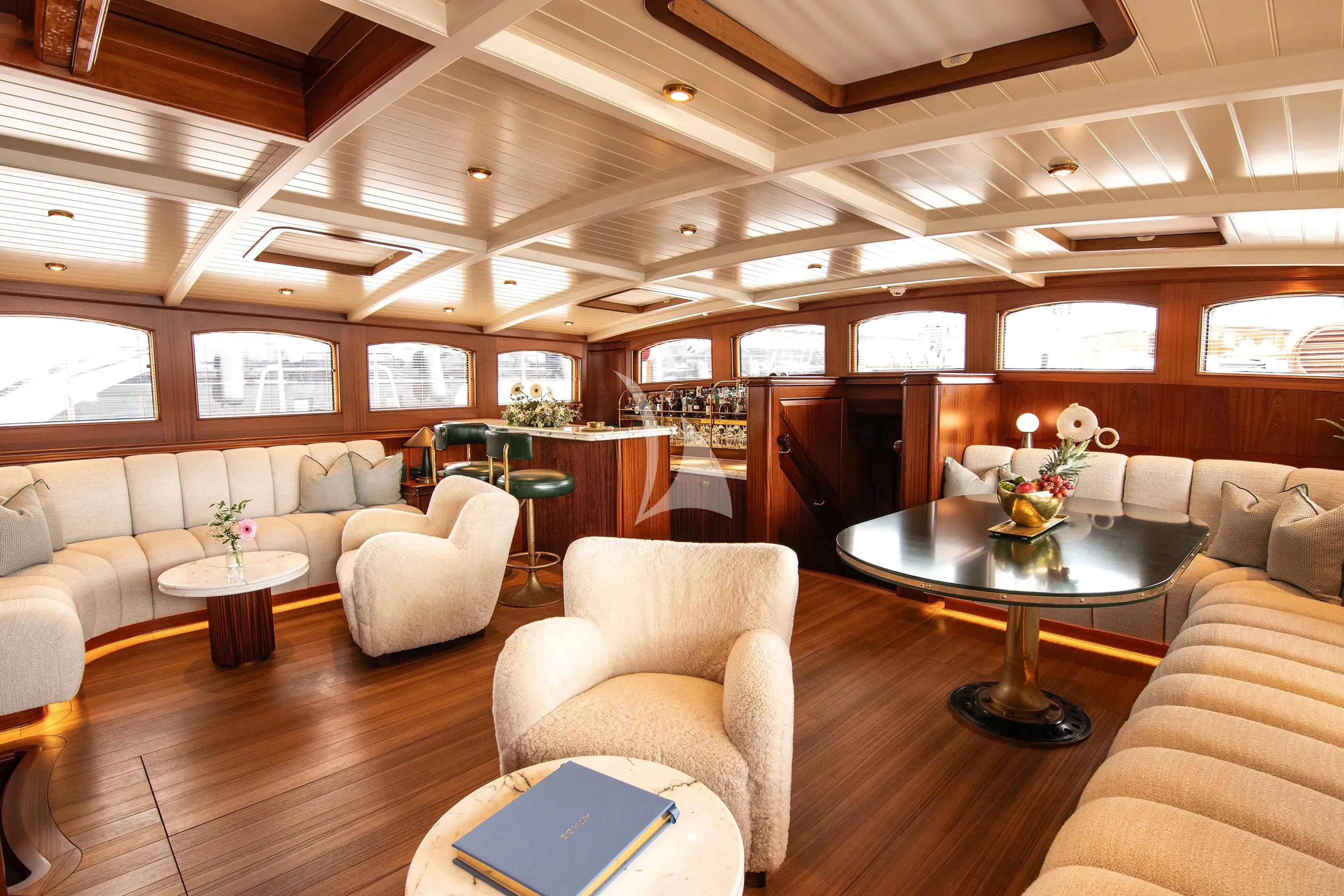 a room with a table chairs and a couch aboard ATHOS Yacht for Sale