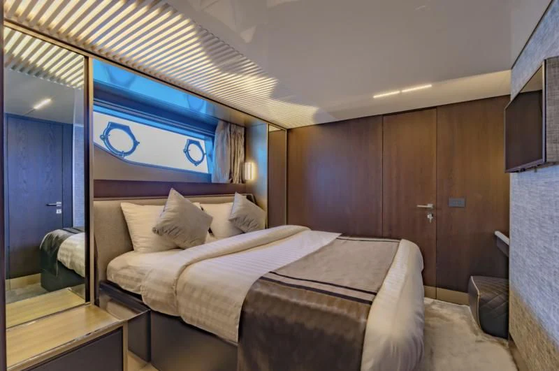 a room with a bed and a television on the wall aboard ORIANT Yacht for Sale