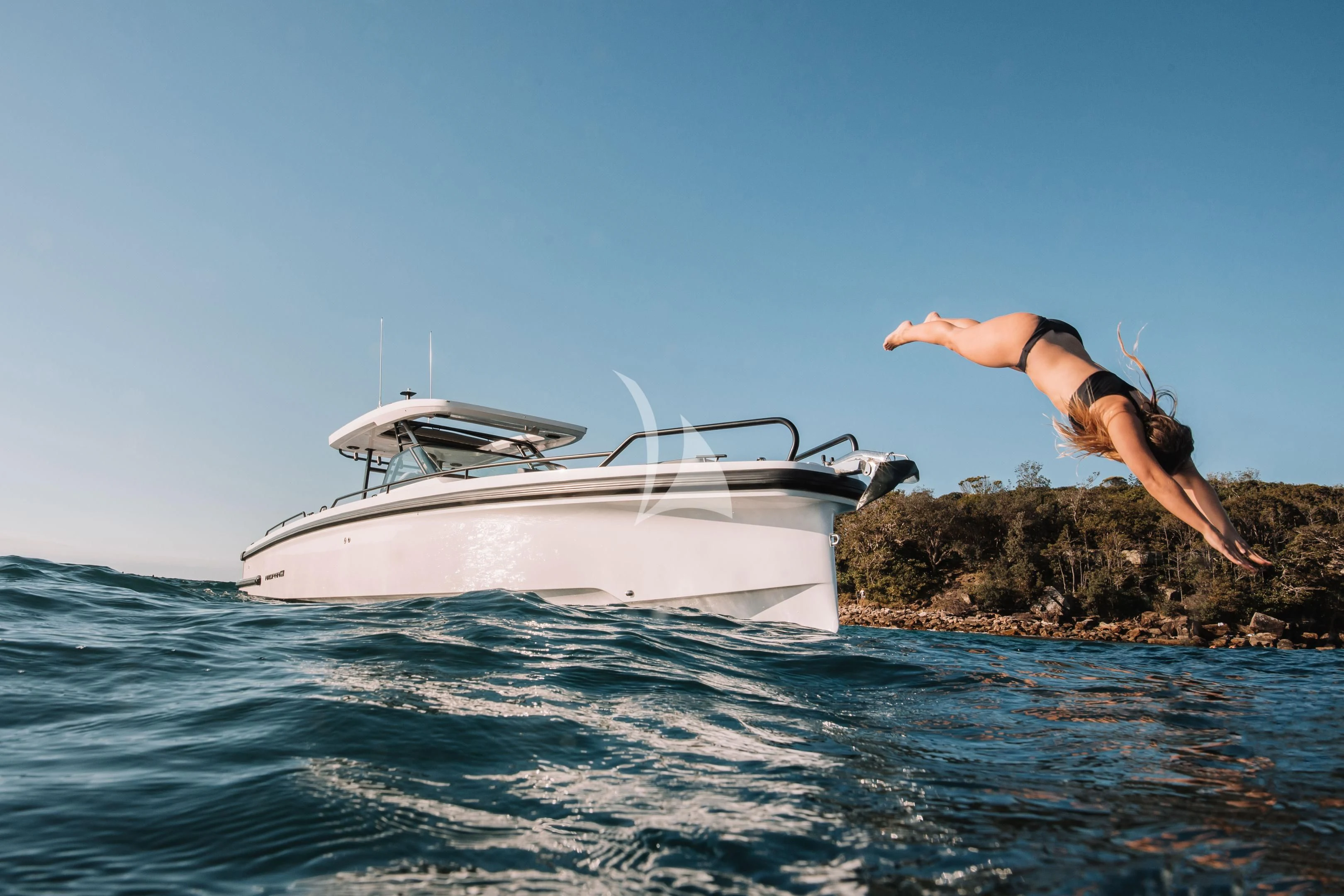 a person jumping into the water next to a white boat aboard AORI Yacht for Sale