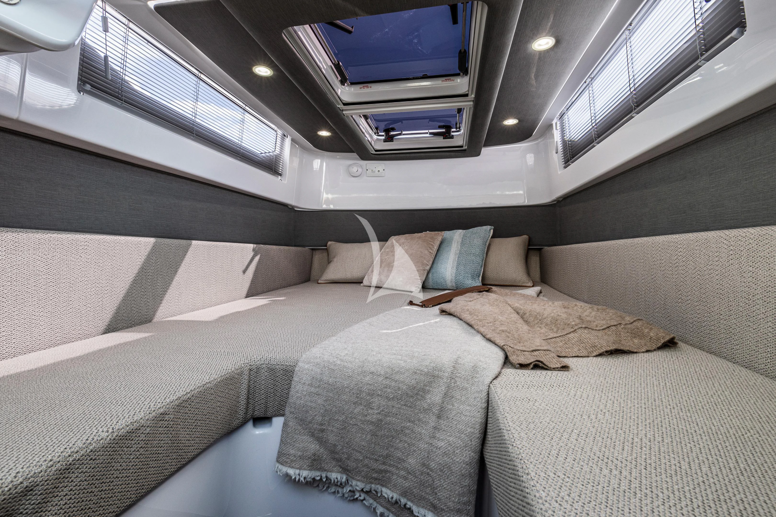 a bed with pillows and a television aboard AORI Yacht for Sale