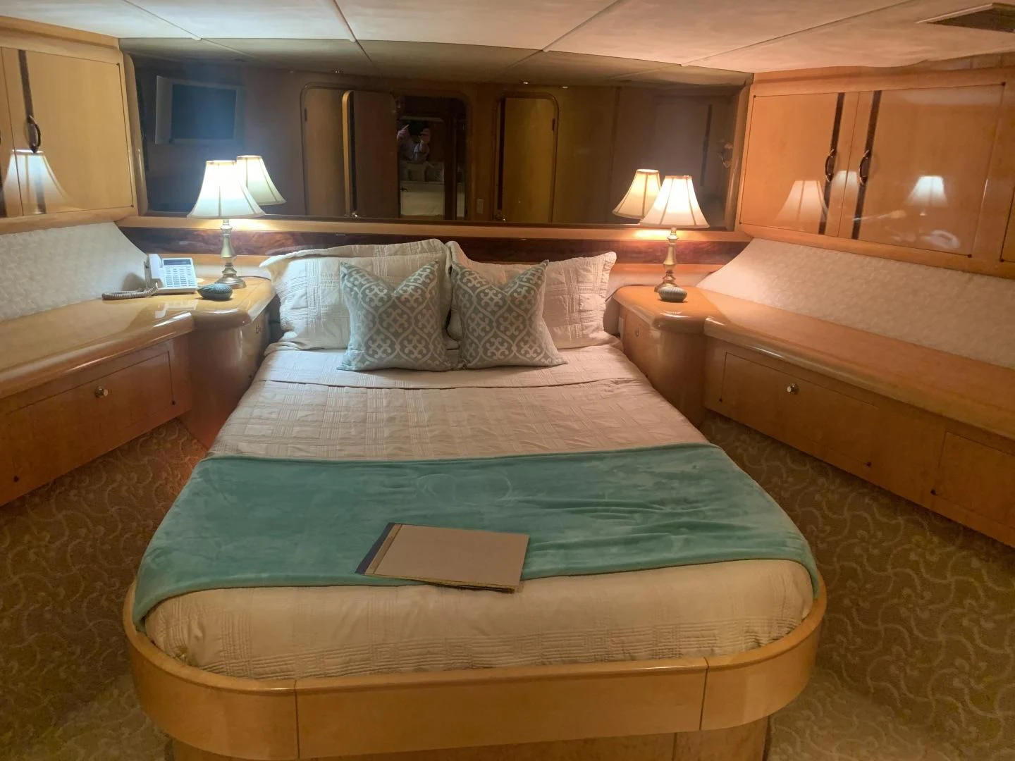 a bed with pillows and a book aboard REHAB Yacht for Sale