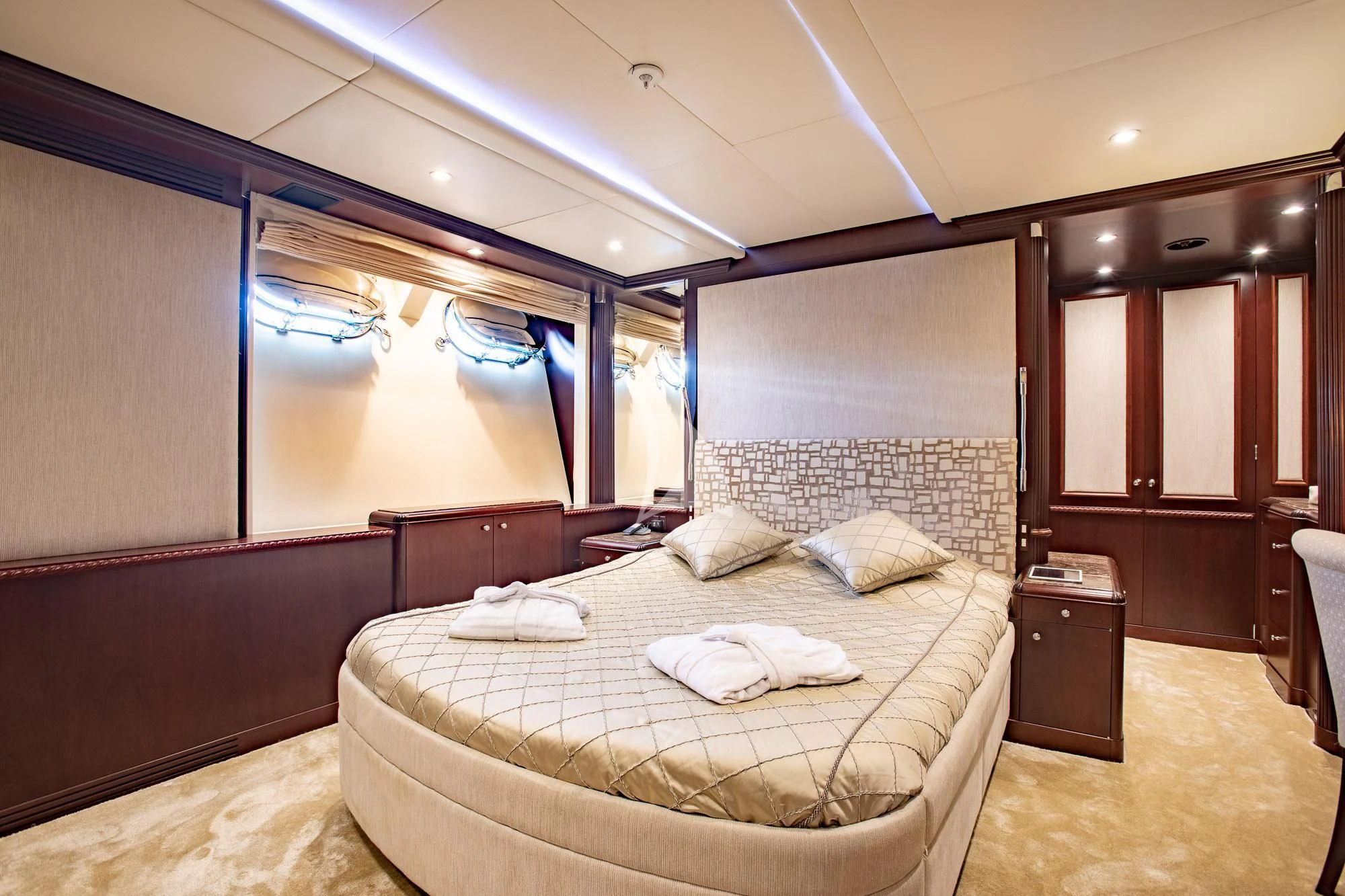 a bedroom with a bed and a window aboard AKIRA ONE Yacht for Charter