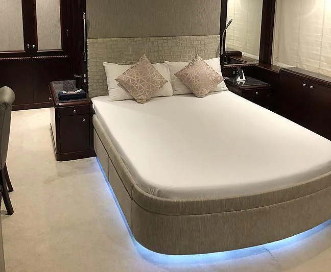 a bed with white sheets aboard AKIRA ONE Yacht for Charter