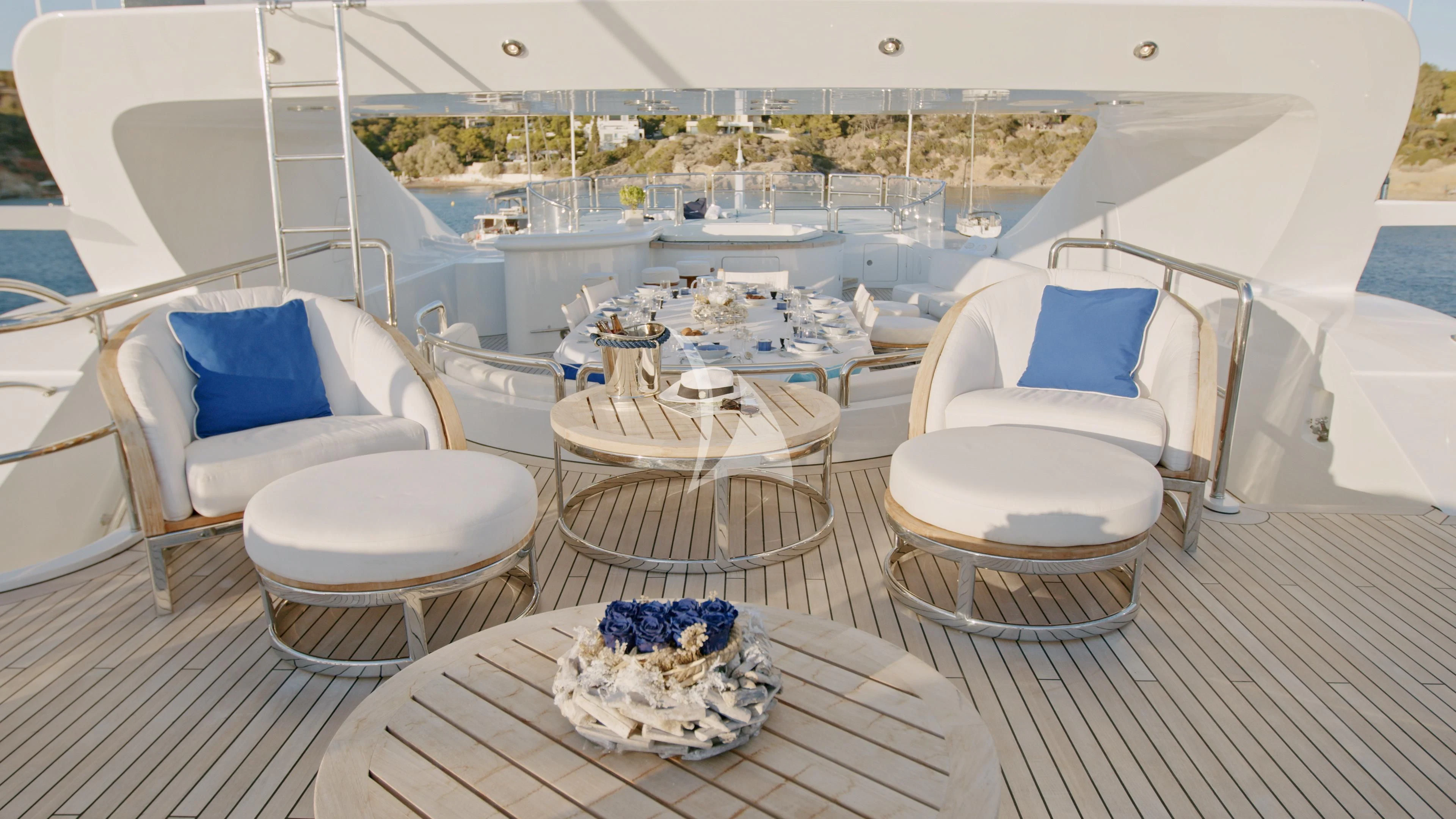 a large white lounge chair on a deck overlooking a large city aboard AKIRA ONE Yacht for Charter