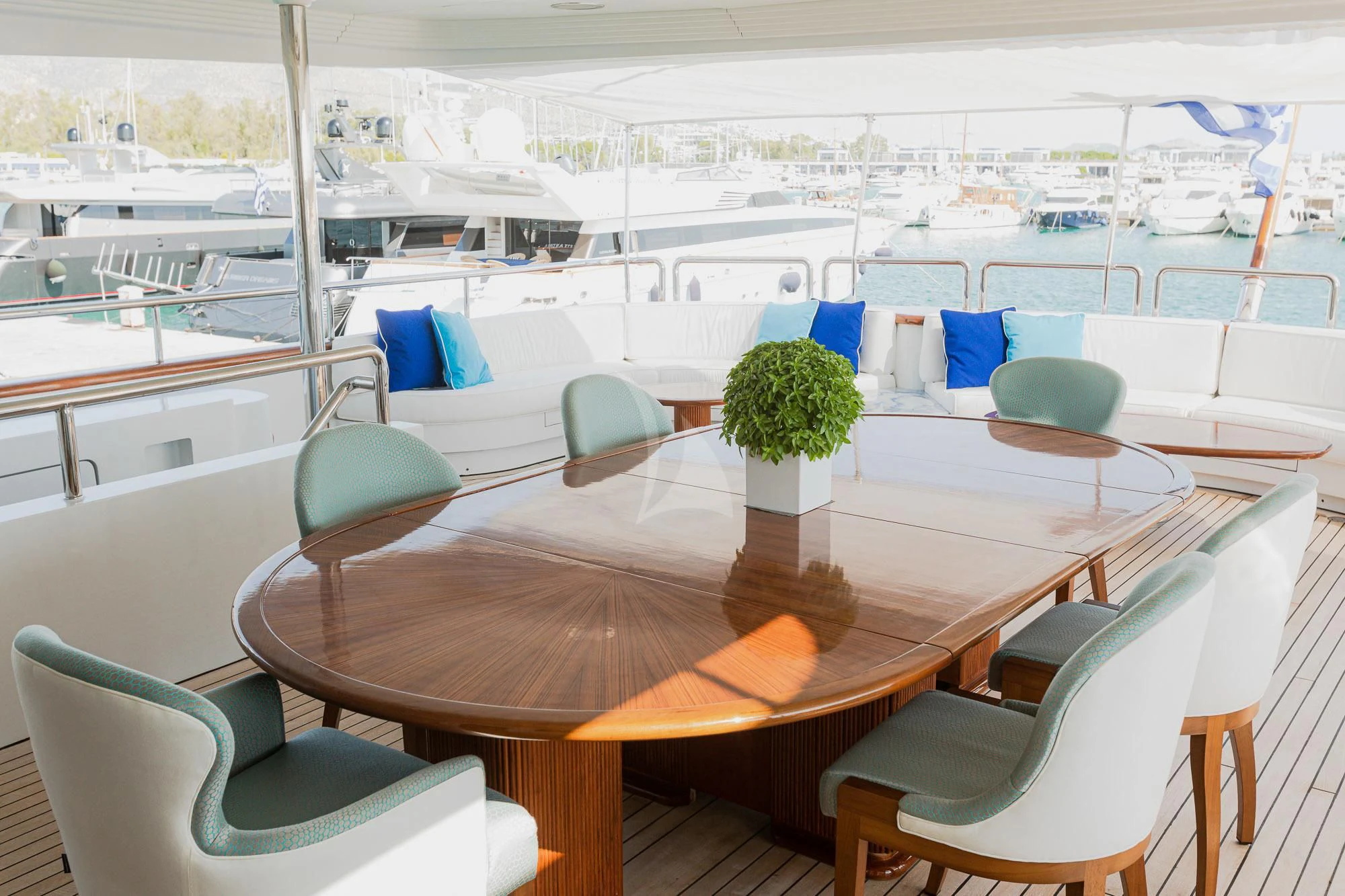 a room with a table chairs and plants on the floor aboard AKIRA ONE Yacht for Charter
