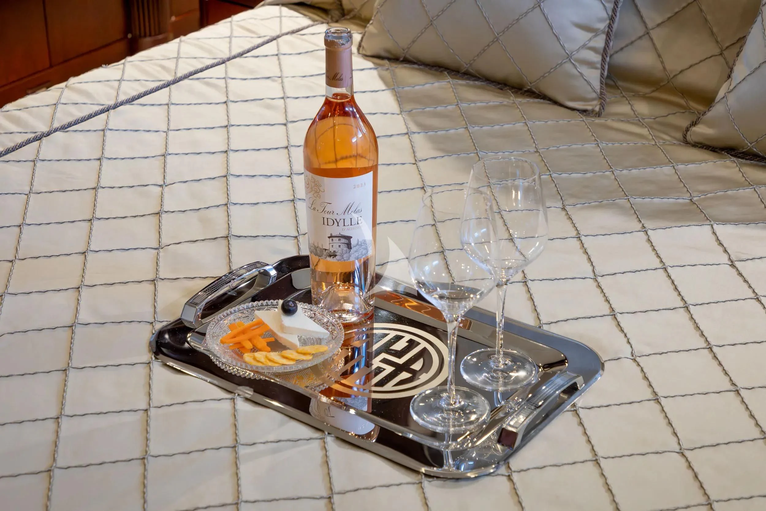 a bottle of liquor and a plate of food on a table aboard AKIRA ONE Yacht for Charter