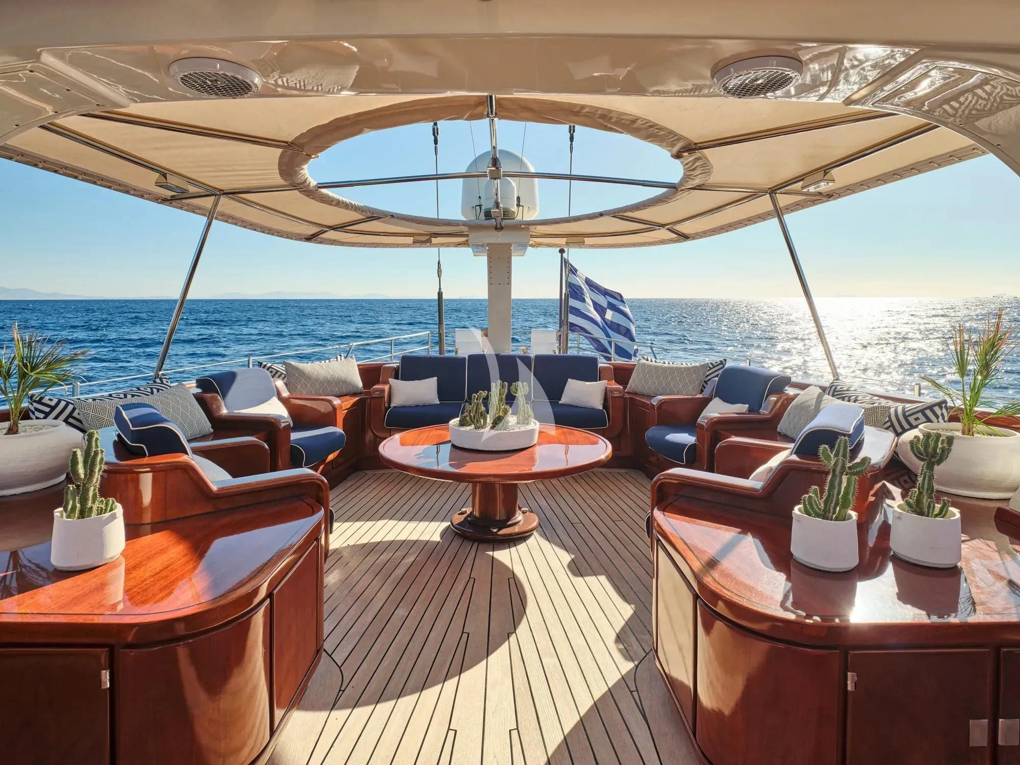 a room with a large patio and a large umbrella over the ocean aboard GITANA Yacht for Charter