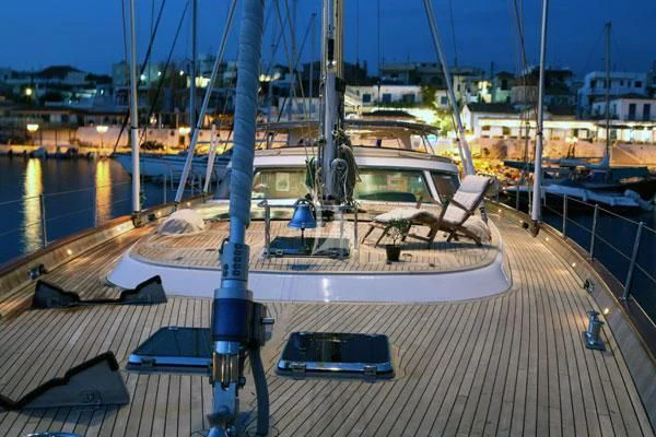 a deck with a deck and a view of a city at night aboard GITANA Yacht for Charter
