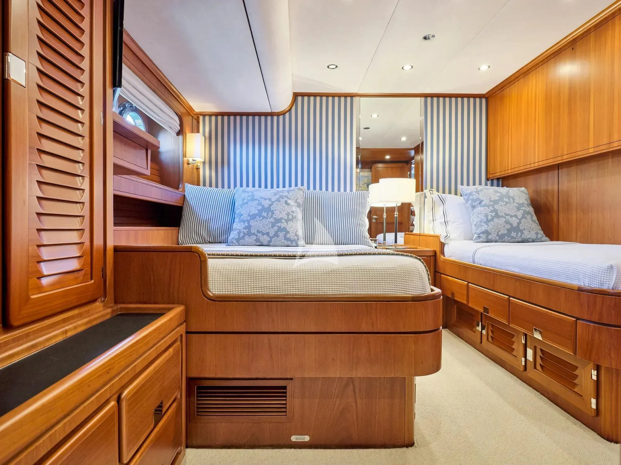 a bedroom with a bed and a dresser aboard GITANA Yacht for Charter