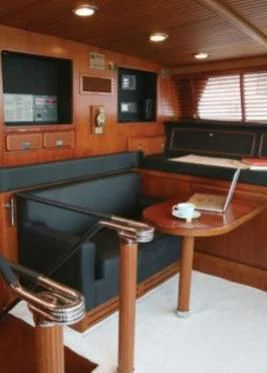 a room with a piano and a table and a television aboard GITANA Yacht for Charter