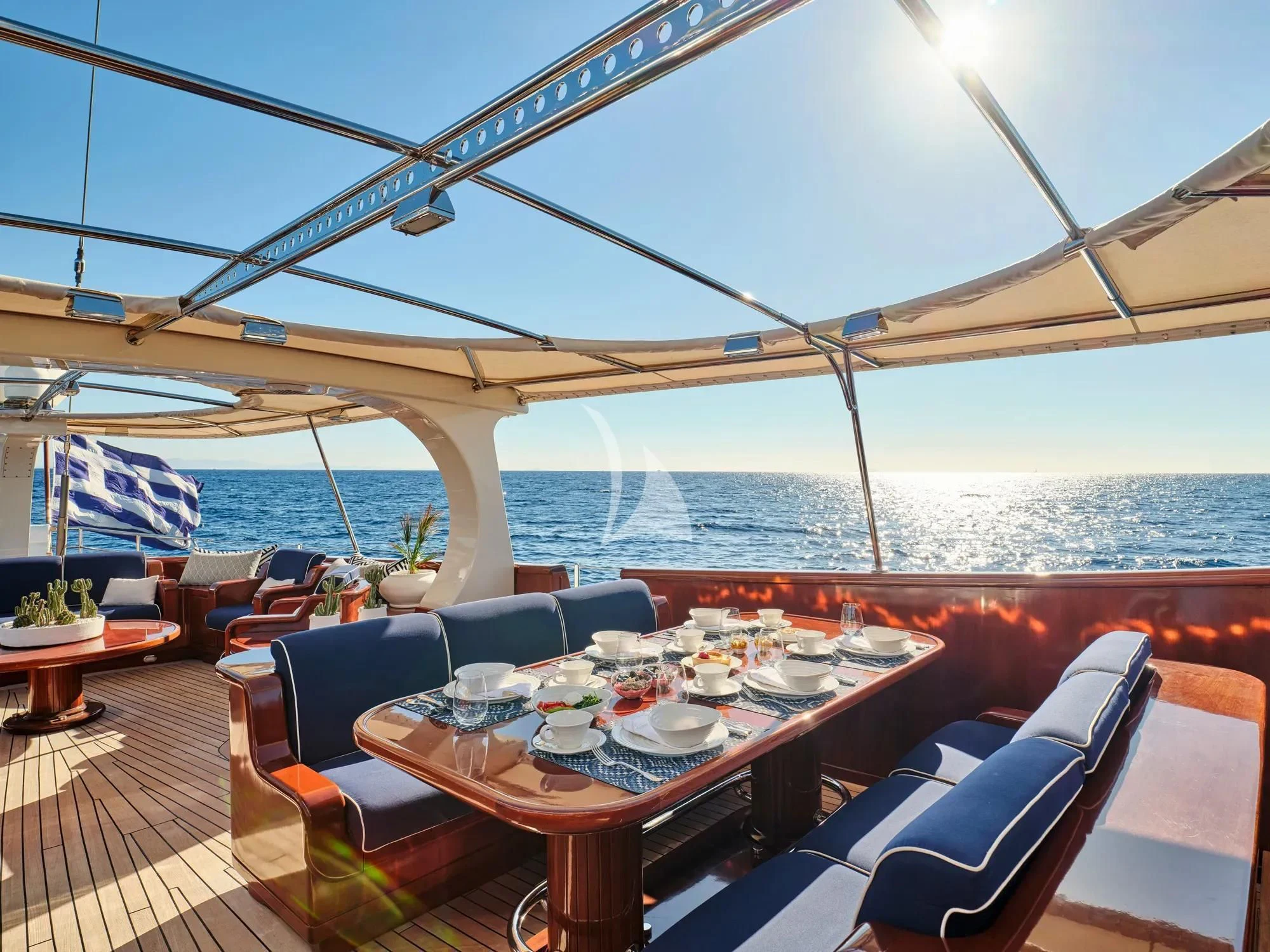 a table set for a meal on a deck overlooking the ocean aboard GITANA Yacht for Charter
