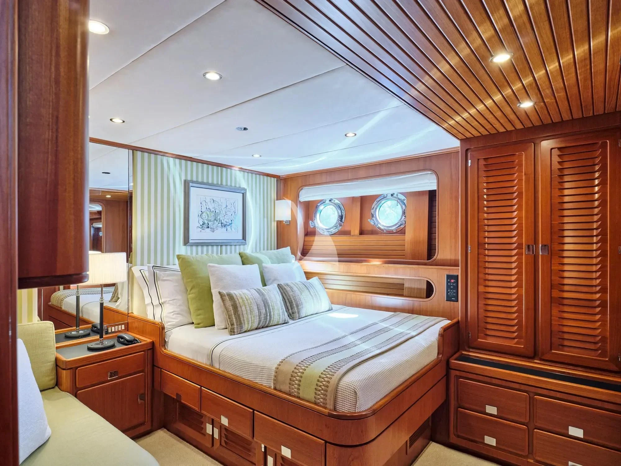 a bedroom with a bed and a dresser aboard GITANA Yacht for Charter