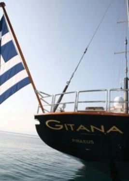 a boat with a flag on it aboard GITANA Yacht for Charter