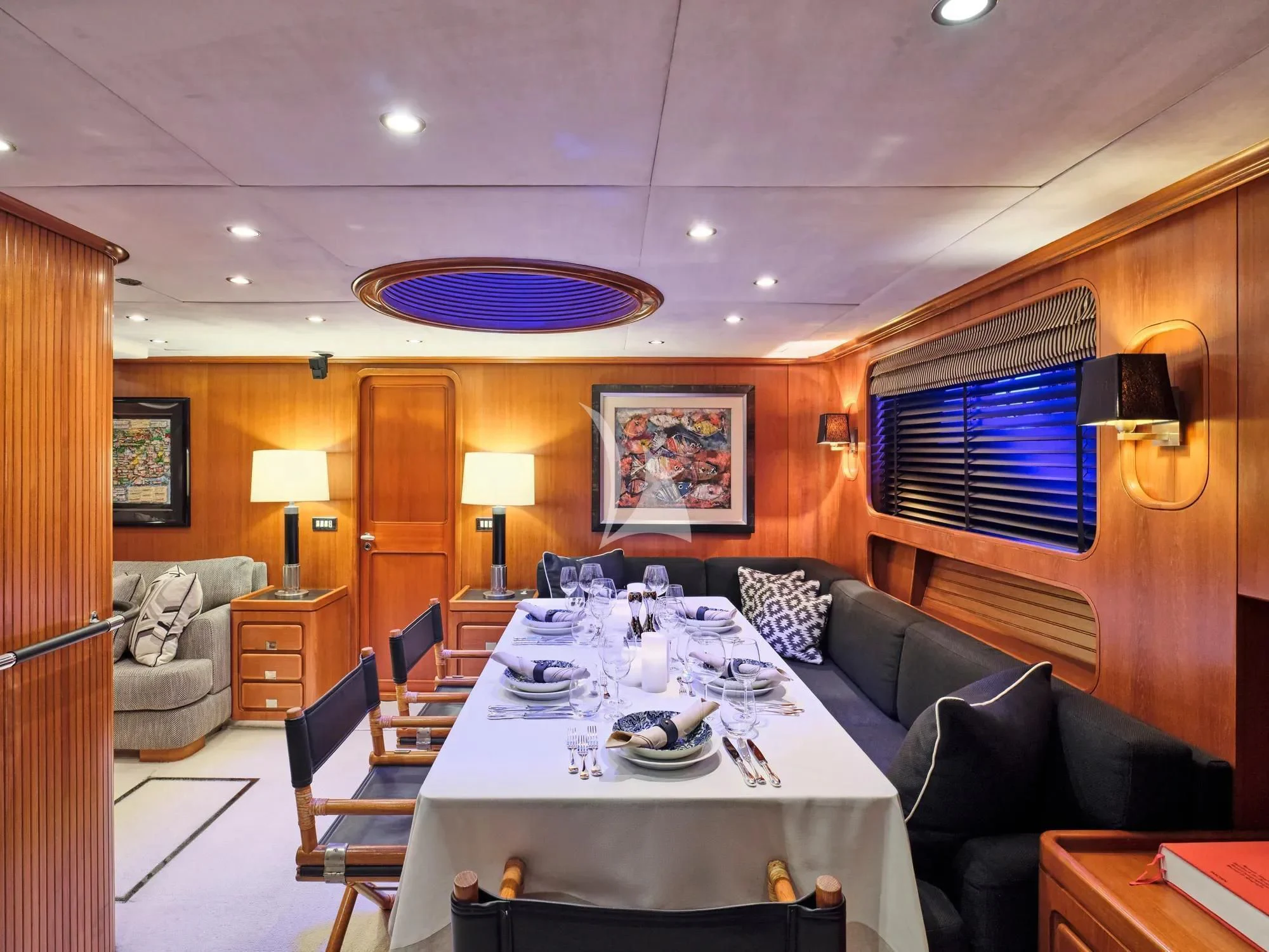 a living room with a large round table and a large window aboard GITANA Yacht for Charter