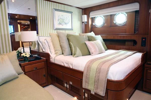a bedroom with a bed and a mirror aboard GITANA Yacht for Charter
