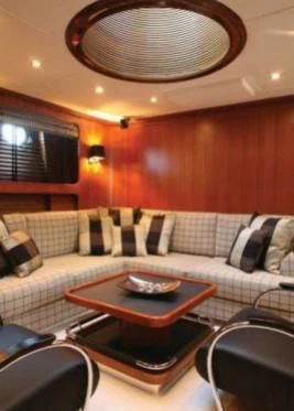 a living room with a couch and a round table aboard GITANA Yacht for Charter