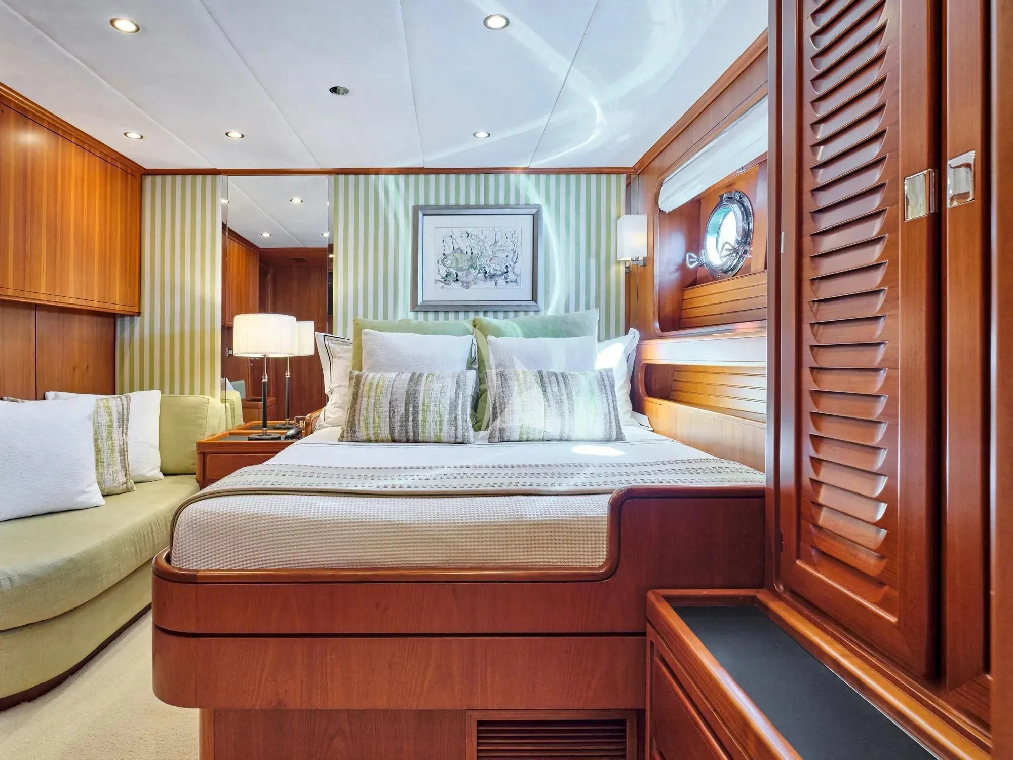 a room with a bed and a mirror aboard GITANA Yacht for Charter