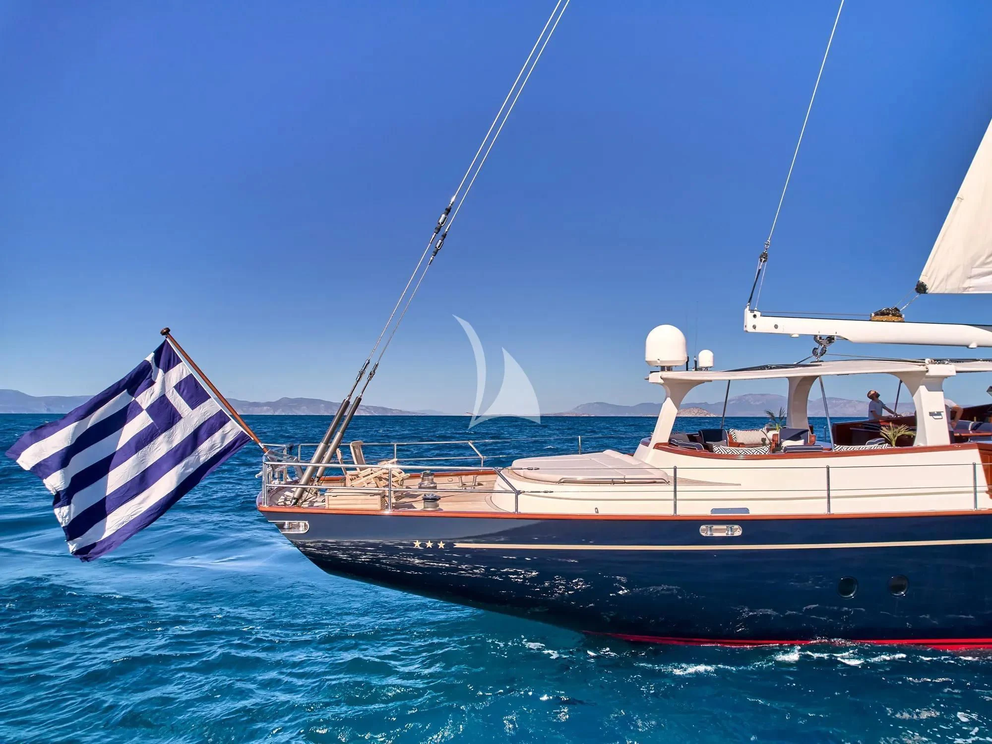 a boat with a flag on it aboard GITANA Yacht for Charter