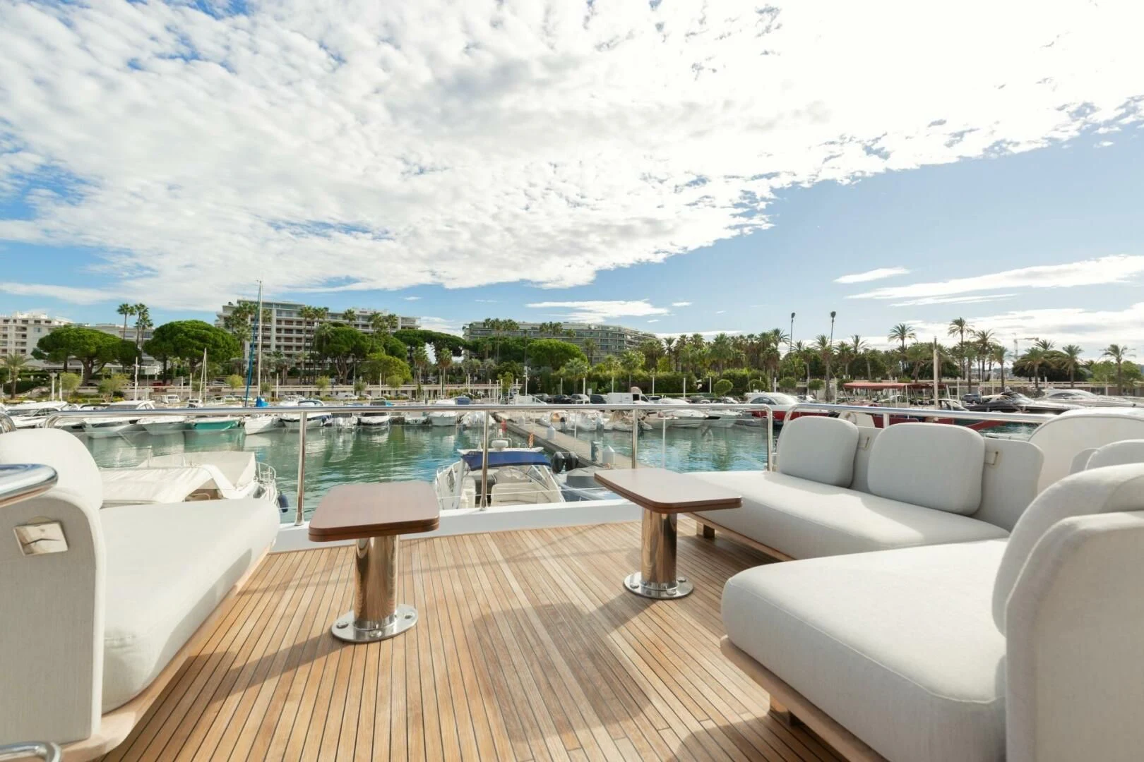 a deck with chairs and tables on it by a body of water aboard AZIMUT 72 Yacht for Sale