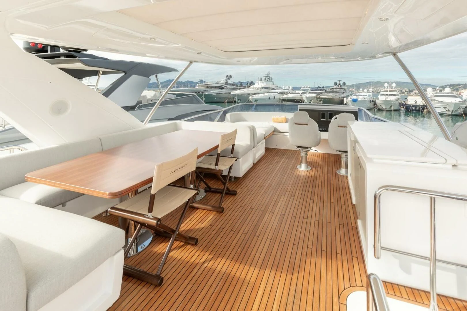 a room with a deck and chairs aboard AZIMUT 72 Yacht for Sale