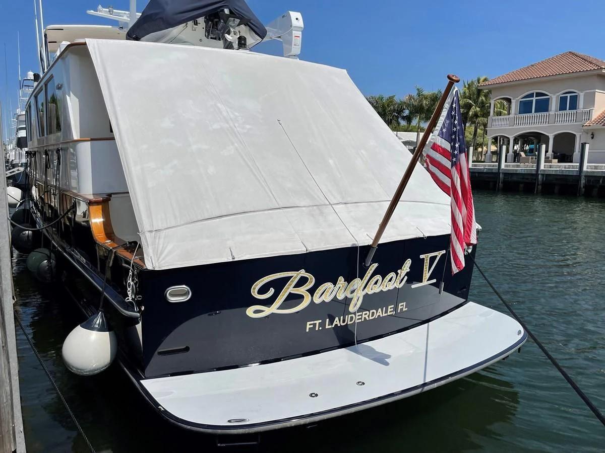 a boat with a flag on the front aboard BAREFOOT V Yacht for Sale